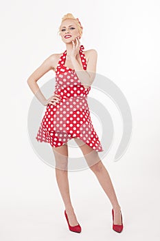 Young beautiful caucasian woman posing in a pin up red dress style