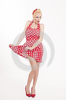 Young beautiful caucasian woman posing in a pin up red dress style