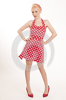 Young beautiful caucasian woman posing in a pin up red dress style