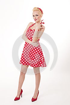 Young beautiful caucasian woman posing in a pin up red dress style