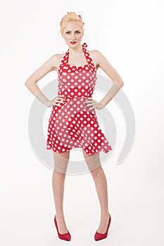 Young beautiful caucasian woman posing in a pin up red dress style