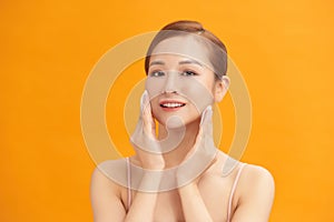 Young beautiful caucasian woman using a cotton pad to remove her make-up