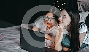 Young beautiful caucasian women`s lesbian couple lover, using laptop computer