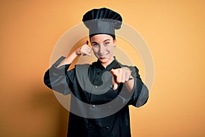 Young beautiful chef woman wearing cooker uniform and hat standing over yellow background smiling doing talking on the telephone