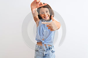 Young beautiful child girl wearing blue casual shirt standing over isolated white background smiling making frame with hands and