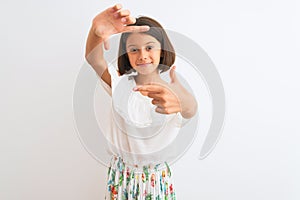 Young beautiful child girl wearing casual dress standing over isolated white background smiling making frame with hands and