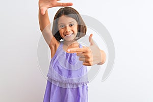 Young beautiful child girl wearing purple casual dress standing over isolated white background smiling making frame with hands and