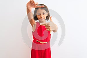 Young beautiful child girl wearing red casual dress standing over isolated white background smiling making frame with hands and