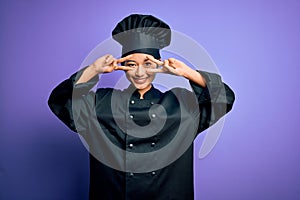 Young beautiful chinese chef woman wearing cooker uniform and hat over purple background Doing peace symbol with fingers over