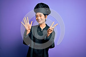 Young beautiful chinese chef woman wearing cooker uniform and hat over purple background showing and pointing up with fingers