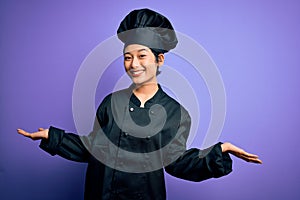 Young beautiful chinese chef woman wearing cooker uniform and hat over purple background smiling showing both hands open palms,