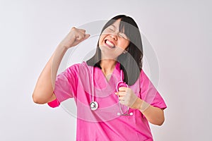 Young beautiful Chinese nurse woman wearing stethoscope over isolated white background very happy and excited doing winner gesture