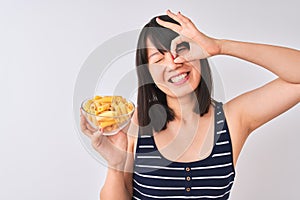 Young beautiful Chinese woman holding bowl with macaroni over isolated white background with happy face smiling doing ok sign with