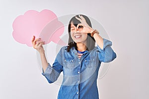 Young beautiful Chinese woman holding cloud speech bubble over isolated white background with happy face smiling doing ok sign