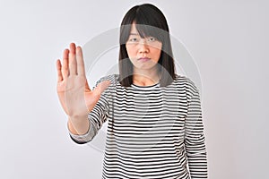 Young beautiful chinese woman wearing black striped t-shirt over isolated white background doing stop sing with palm of the hand