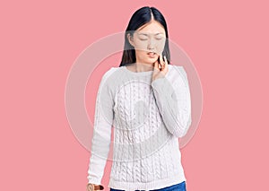 Young beautiful chinese woman wearing casual sweater touching mouth with hand with painful expression because of toothache or