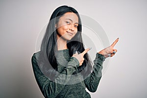 Young beautiful chinese woman wearing casual t-shirt over isolated white background smiling and looking at the camera pointing