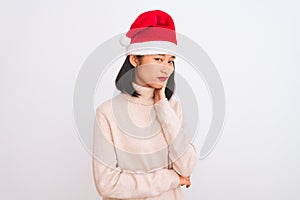 Young beautiful chinese woman wearing Christmas Santa hat over isolated white background thinking looking tired and bored with