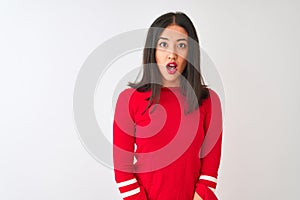 Young beautiful chinese woman wearing red dress standing over isolated white background afraid and shocked with surprise