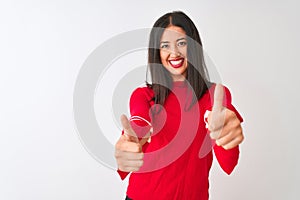 Young beautiful chinese woman wearing red dress standing over isolated white background approving doing positive gesture with