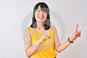 Young beautiful chinese woman wearing yellow t-shirt over isolated white background smiling and looking at the camera pointing