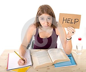 Young beautiful college student girl studying for university exam in stress asking for help under test pressure