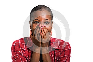 Young beautiful and cool black African American woman in casual shirt and shaved hair excited and surprised isolated on dark