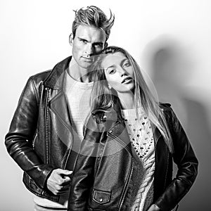 Young beautiful couple in black leather jackets. Black-white portrait.