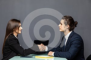 Young beautiful couple of business workers smiling happy and confident shaking hands with smile on face for agreement at office on