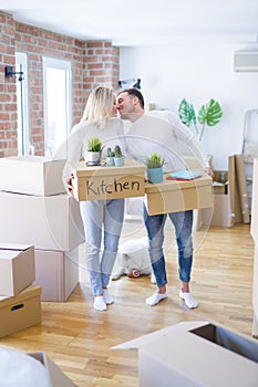 Young beautiful couple with dog moving cardboard boxes at new home