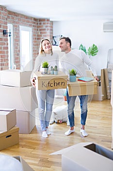 Young beautiful couple with dog moving cardboard boxes at new home
