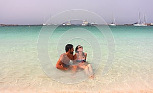Young beautiful couple enjoys an early morning lonely bath in Espalmador beach, one of the most beautiful spots in Formentera.