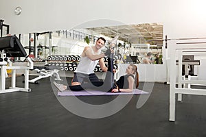 Young beautiful couple exercising in gym.