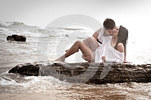 Young beautiful couple flirting and kissing at the beach