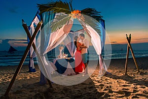 Young beautiful couple have a romantic dinner at sunset