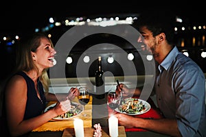 Young beautiful couple having romantic dinner on rooftop