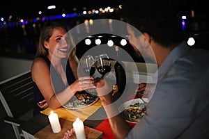 Young beautiful couple having romantic dinner on rooftop