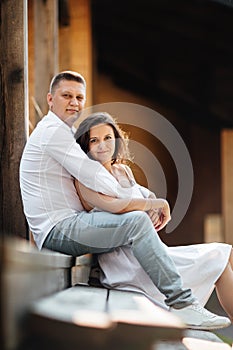 Young beautiful couple is hugging in the field in summer. woman with long hair and man with stylish haircut.