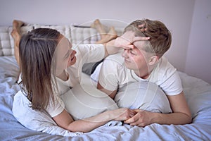 a young beautiful couple hugging and kissing in bed, wellness at home