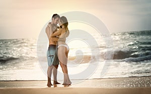 Young beautiful couple in love on the beach on sunset