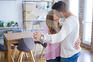 Young beautiful couple in love celebrating dancing moving to a new home, smiling very happy for new apartment