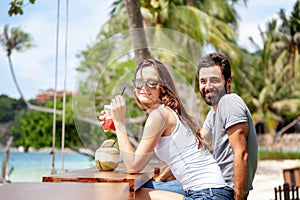 Young beautiful couple in love on the tropical sea in beach cafe, during a honeymoon holiday, Valentine`s Day. Love concept
