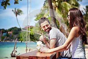 Young beautiful couple in love on the tropical sea in beach cafe, during a honeymoon holiday, Valentine`s Day. Love concept