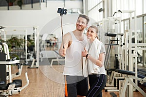 Young beautiful couple making photo at gym.