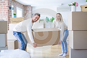 Young beautiful couple moving cardboard boxes at new home