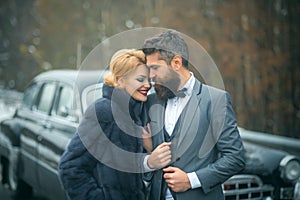 Young beautiful couple relaxing together walking at a retro car. Vintage people.