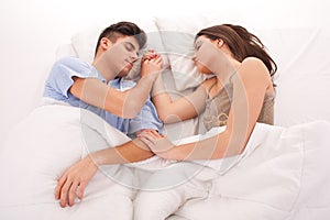 Young beautiful couple sleeping together in bed