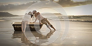 Young beautiful couple spending afternoon on beach with old bath tub