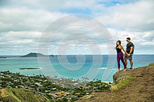 Young beautiful couple standing on a cliff while hiking the Inst