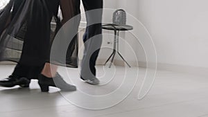 Young beautiful couple studying ballroom dance. A professional ballroom dancing couple dances in a large, bright, white hall.